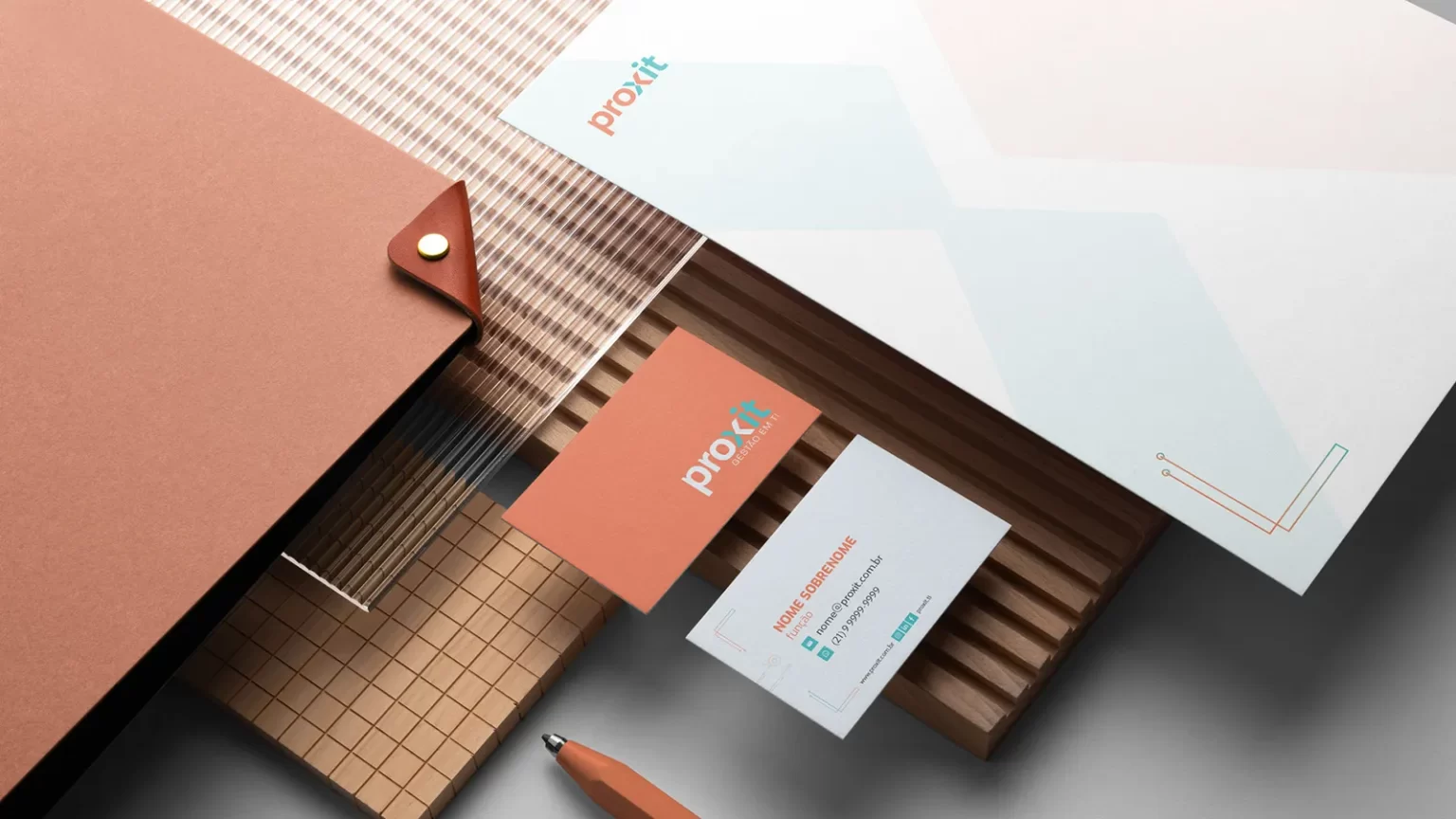 A set of business cards and a pen on a wooden table, showcasing brand design.