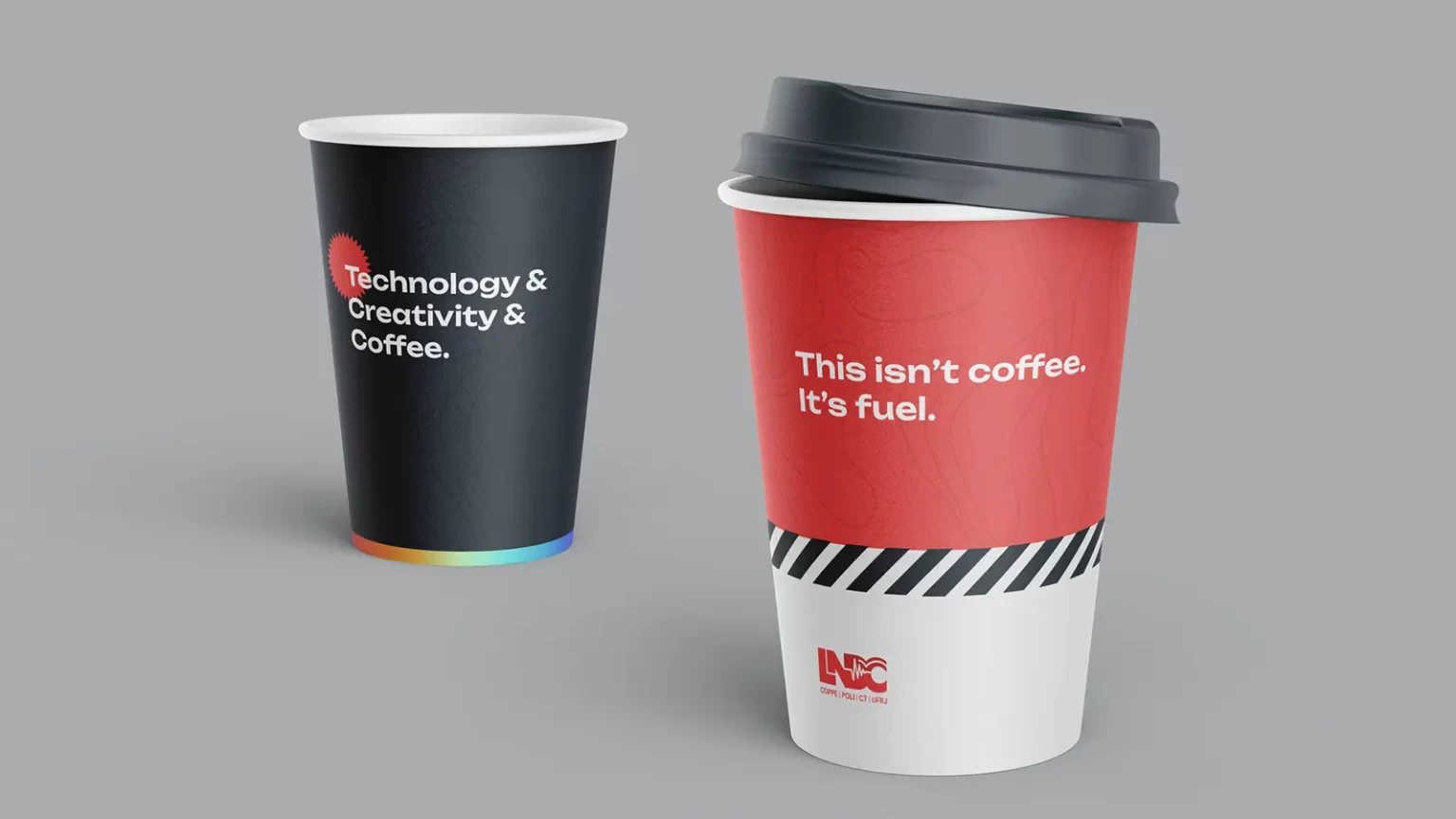 Two cups with lids, one is dark blue and it's written "Technology & Creativity & Coffe", the other is half red and it says "This isn't coffee. It's fuel."